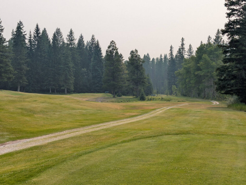 A cart path winding through the undulating fairways at Sparwood Golf Club
